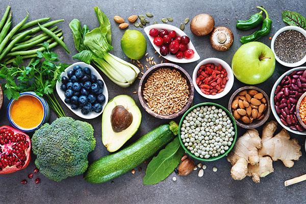 A vibrant array of fresh fruits and vegetables displayed on a dark surface, with each item separated by color.